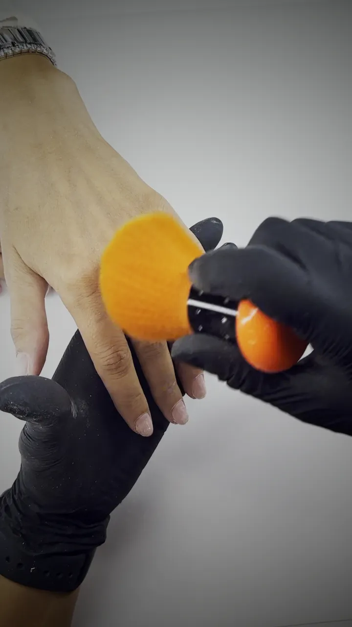 A dust brush sweeping a finished nail, filmed from above